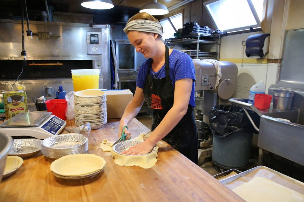 Preparing the pie tins with the help of kitchen scissors