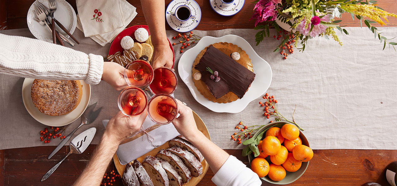 Holiday Preorder Dessert Spread on Table with hands cheersing